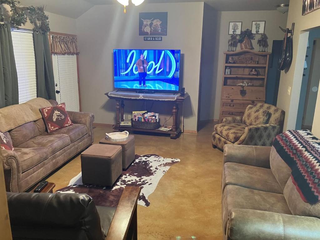 un soggiorno con una TV, un divano e un tavolo di And Boots Start Knocking 3 beds Super Host Status a Stillwater