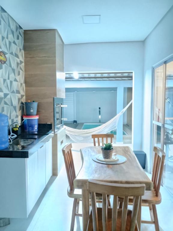 a kitchen with a wooden table and chairs in a room at Refúgio do Mar in Japaratinga