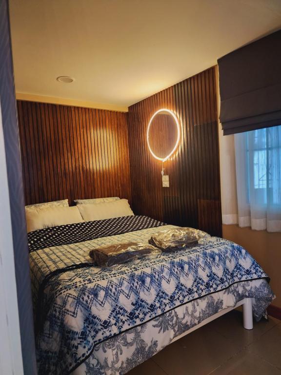 Un dormitorio con una cama y un espejo en la pared. en My Little House in Bangkok, en Don Muang Airport