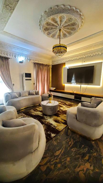 un ampio soggiorno con divani e TV a schermo piatto di Sunabi Hotels and Apartments ad Abuja