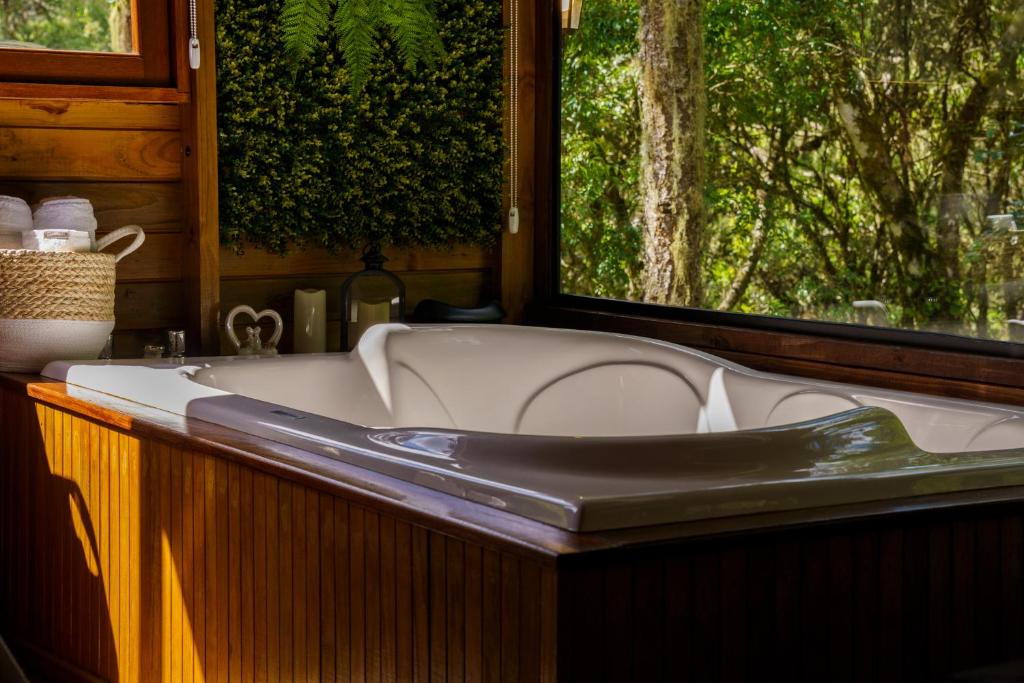 Rio FortunaにあるMaravilhoso Chalé em Urubiciの窓のある部屋にある浴槽