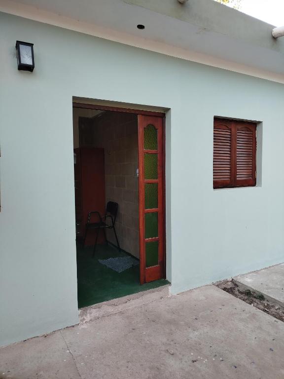 a white building with a red door and a window at Habitación para 3 in Belén