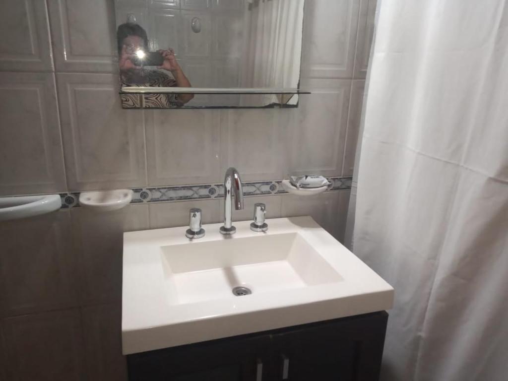 a person taking a picture of a sink in a bathroom at Divina providencia in Merlo