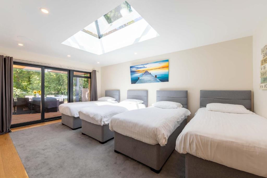 three beds in a room with a skylight at lakeside Lodge in Bristol