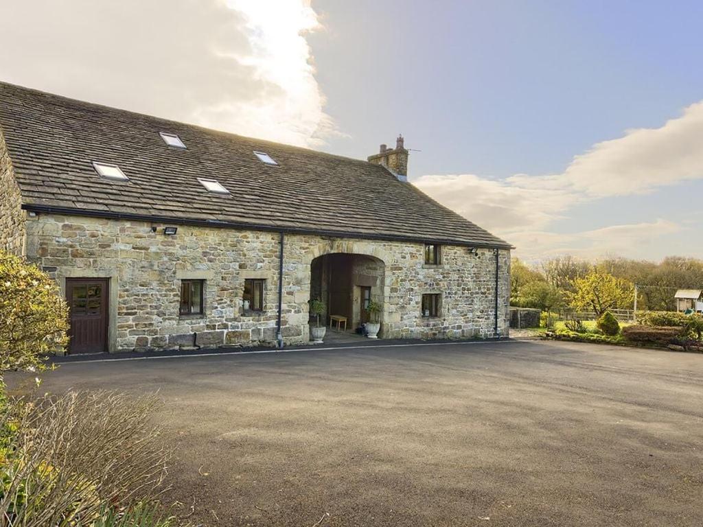an old stone building with a large driveway at Grains Barn Farm in Burnley