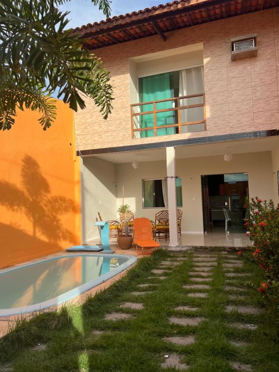 een huis met een zwembad ervoor bij Aconchego Paracuru in Paracuru