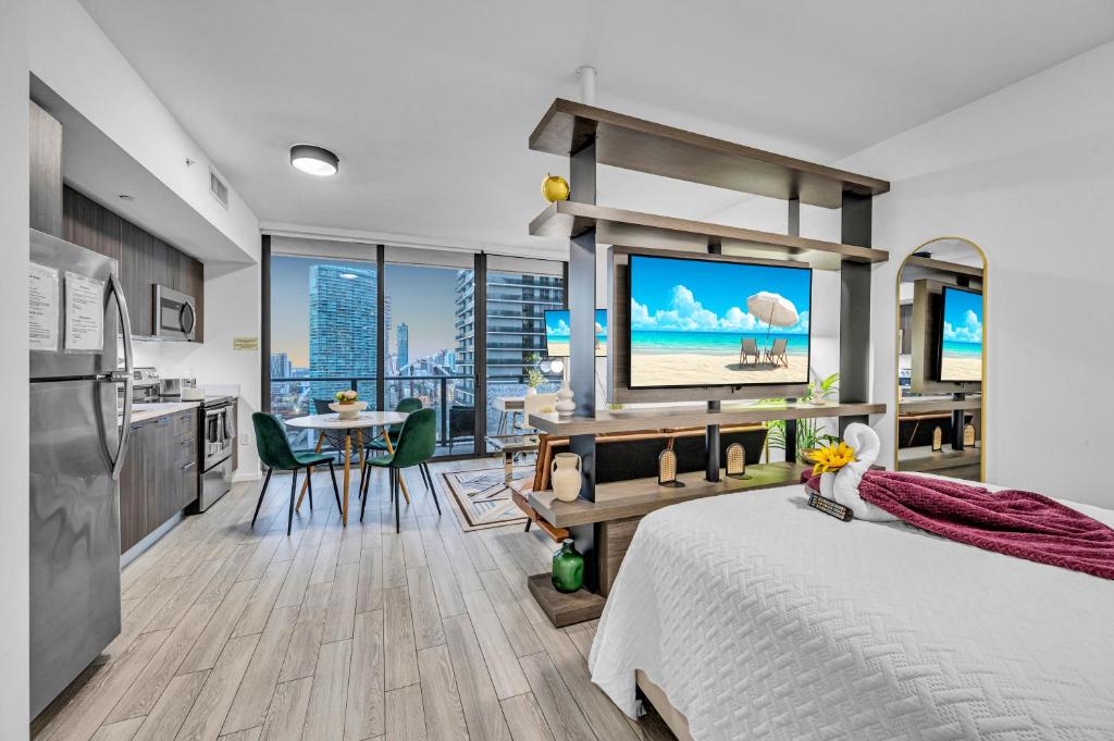 a bedroom with a bed and a kitchen with a television at Modern Studio City Views in Miami