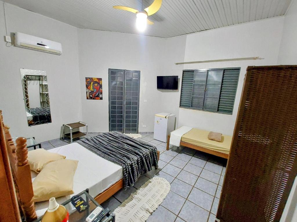 a bedroom with a bed and a window and a tv at Hotel Pasettus in Bela Vista do Paraíso