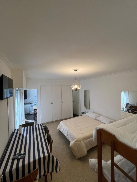 a bedroom with two beds and a chandelier at Depto 1 ambiente frente al mar y céntrico in Mar del Plata