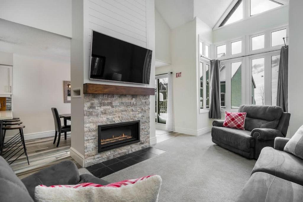 Il comprend un salon doté d'une cheminée et d'une télévision à écran plat. dans l'établissement Slopeside Haven - Ski-In Ski-Out Adventure Base, à Blue Mountains