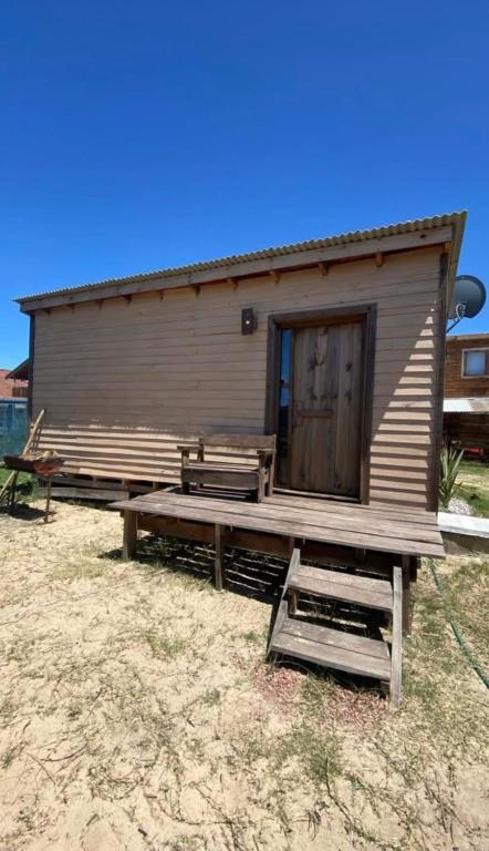 a small cabin with a bench in front of it at Cabaña Cica in Punta Del Diablo