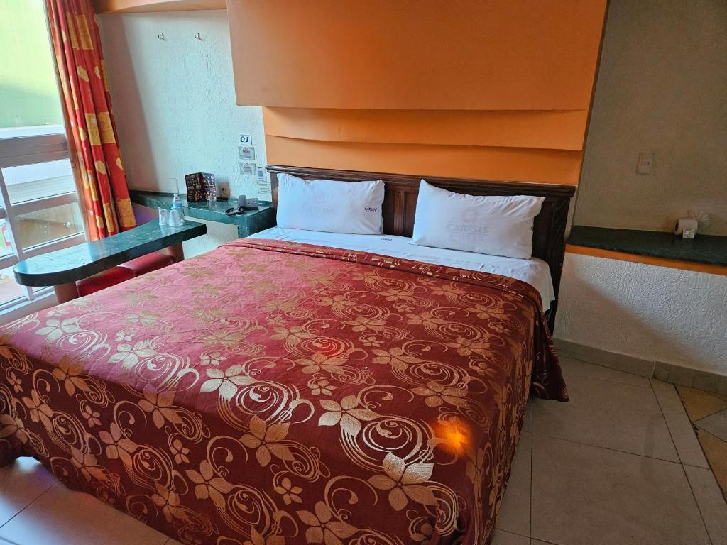 een slaapkamer met een groot bed met een rode deken bij Motel Éxtasis in Mexico-Stad
