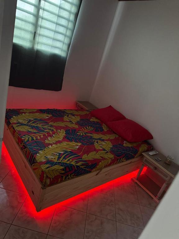 a bedroom with a bed with a red light at F2 moderne et tranquille in Saint-Joseph