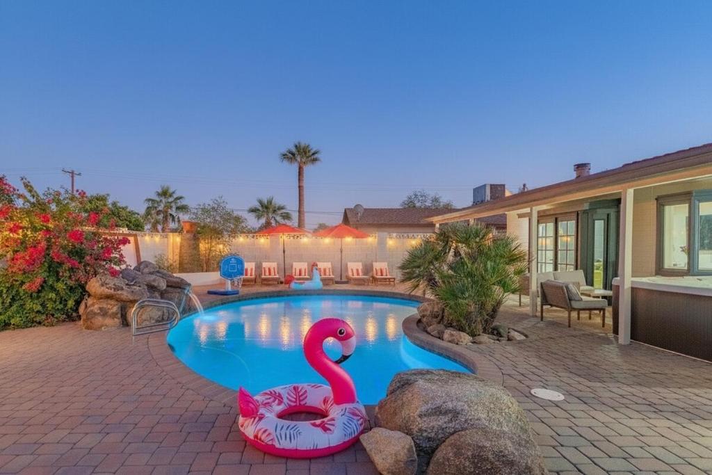 a swimming pool with a pink flamingo in a yard at Ella Oasis Heated Pool Hot Tub Near Old Town in Scottsdale