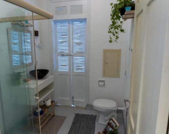 a bathroom with a toilet and a glass shower at Pousada Hostel Trilhas e Rotas in Sao Paulo