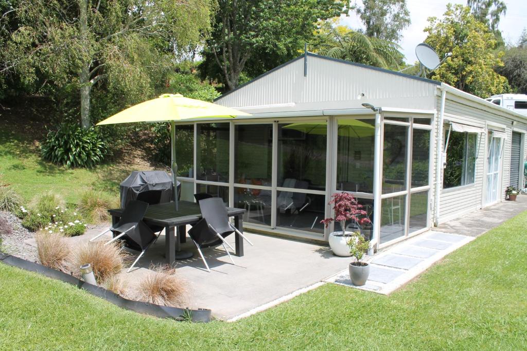 a screened in porch with a table and an umbrella at Jacks Place in Tauranga