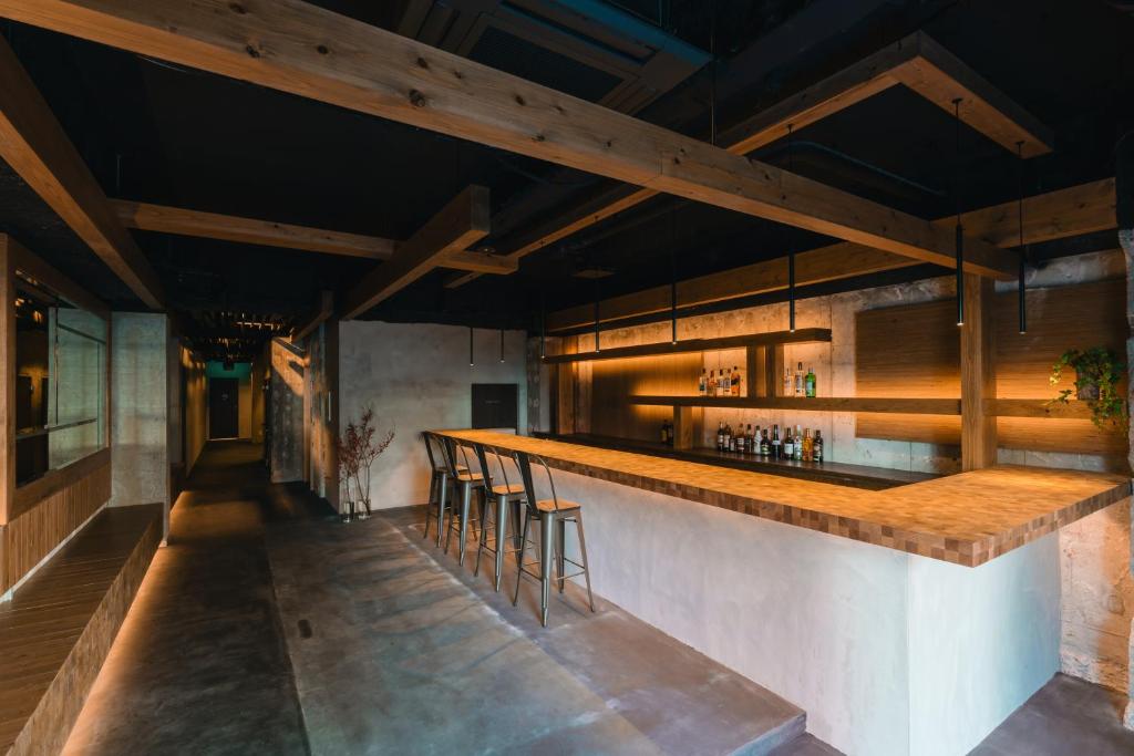 a bar in a restaurant with wooden ceilings at 3U NAMBA MINAMI - DOYANEN HOTELs in Osaka