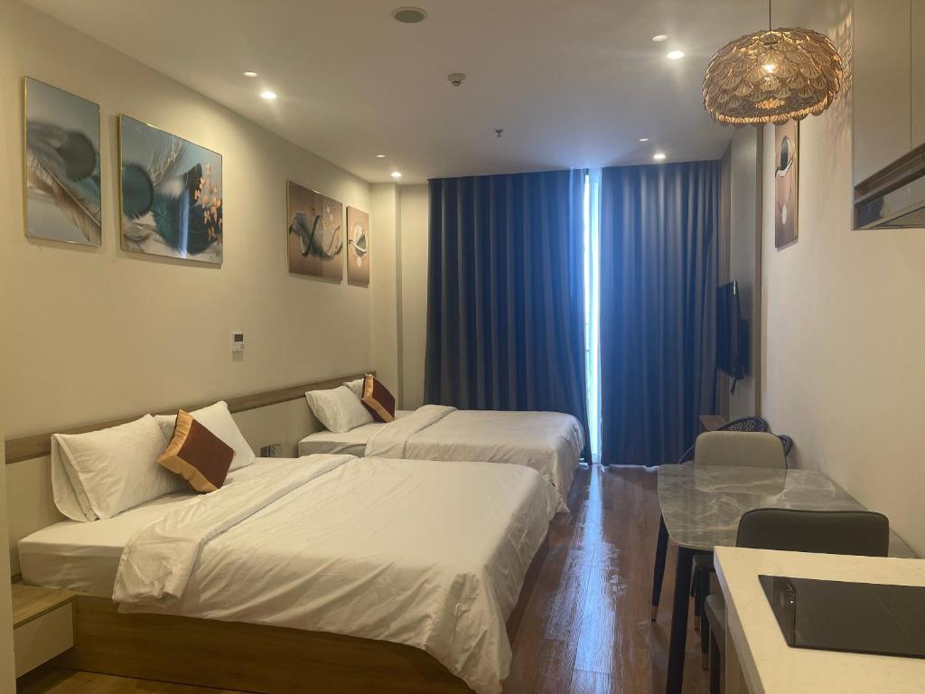 a hotel room with two beds and a table at HomeStay ICON40 HẠLONG in Ha Long