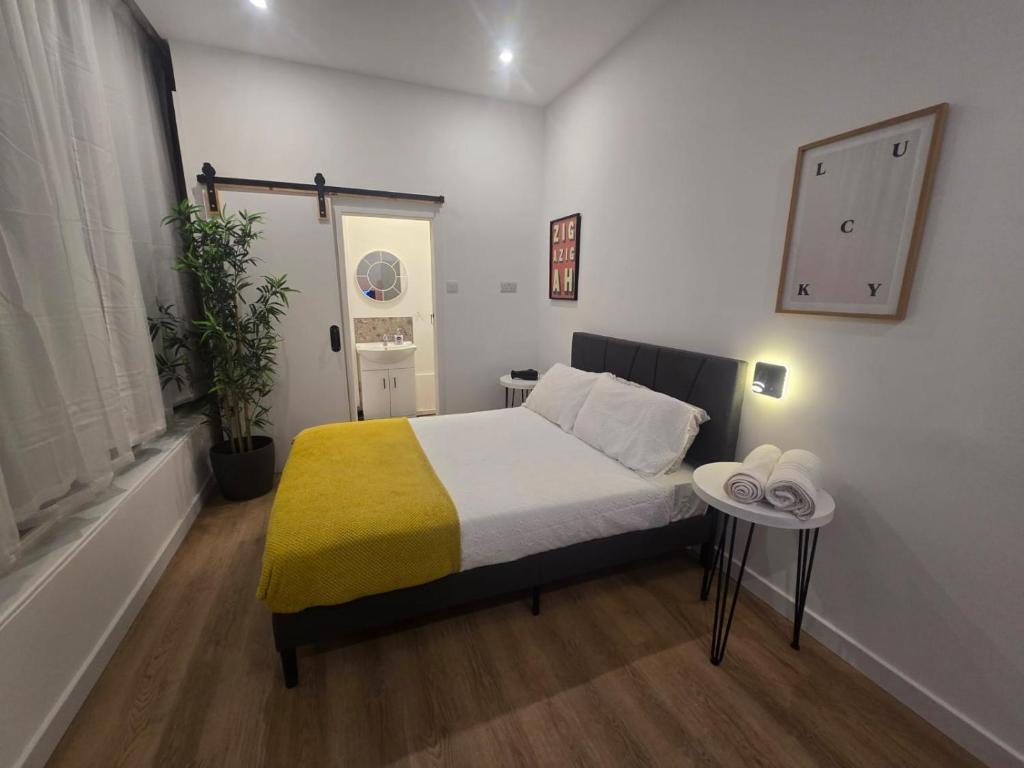 a small bedroom with a bed with a yellow blanket at Stokey Six in London