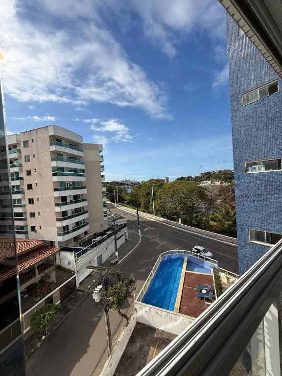 a view of a street and a swimming pool from a building at Apartamento com vista da Baía do Pontal in Ilhéus