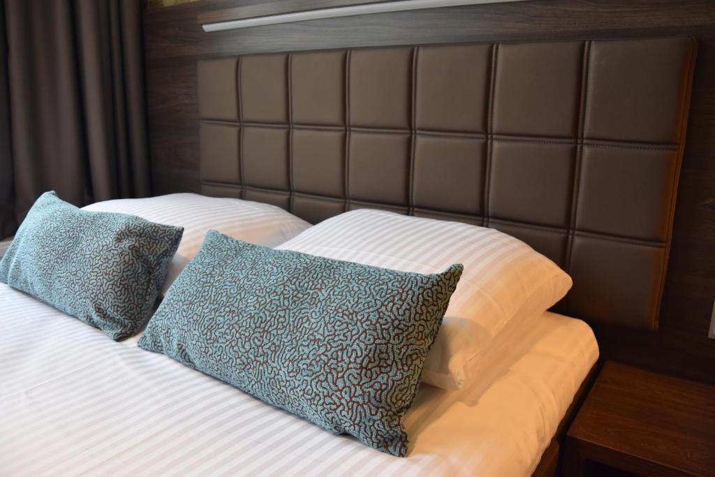 
a bed with a blanket and pillows on it at OZO Hotels Armada Amsterdam in Amsterdam
