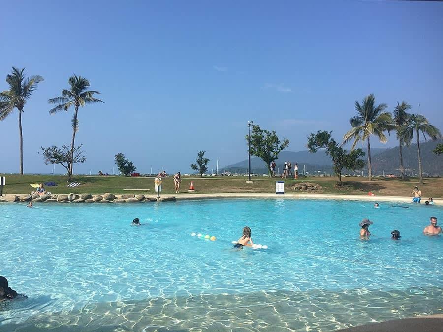 a group of people swimming in a large swimming pool at Sunrise Cove in Airlie Beach