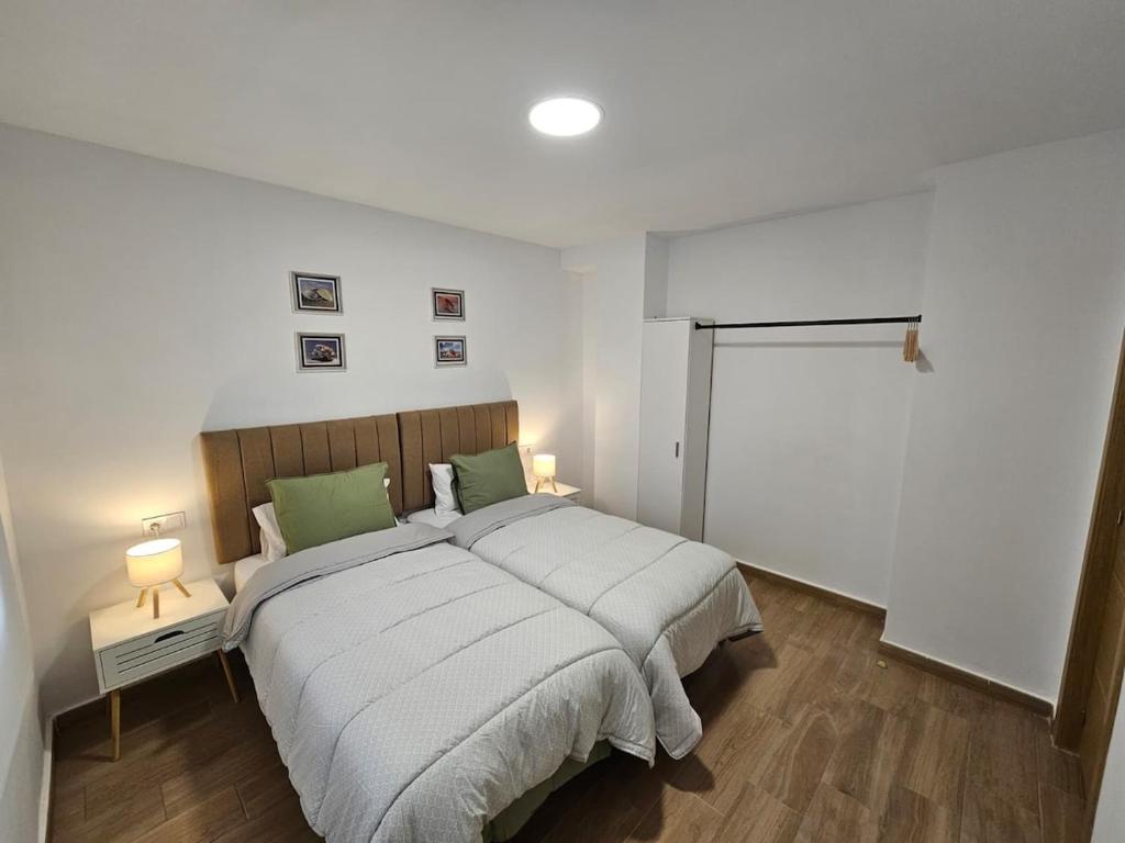 a bedroom with a large bed and two lamps at Casa Hernán Cortés in Málaga
