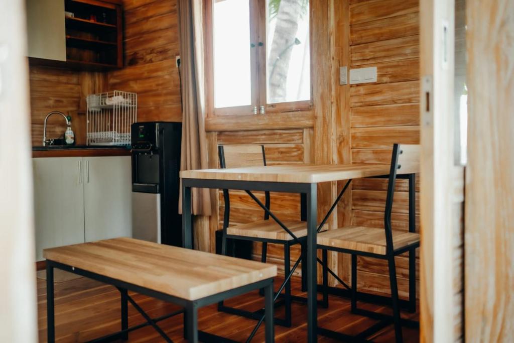 Una pequeña cocina con una mesa y dos sillas. en Kubu He Mamatica, en Tianyar