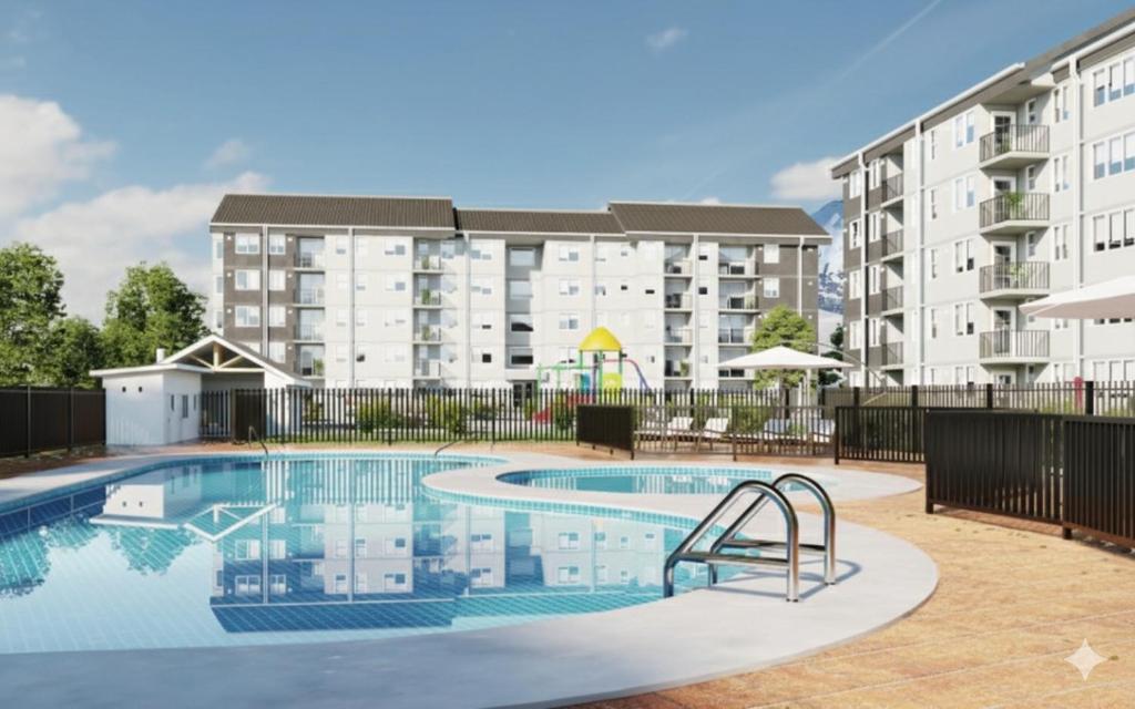 a swimming pool in front of a apartment building at Departamento con vista al Volcán in Villarrica