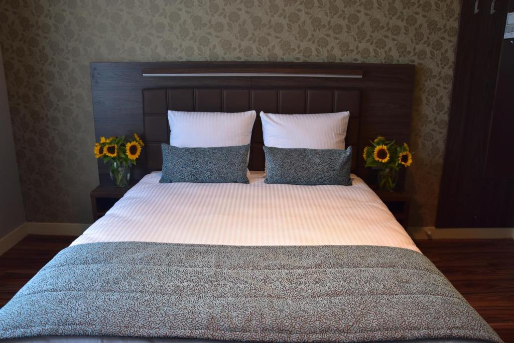 a bedroom with a bed with two pillows and flowers at OZO Hotels Armada Amsterdam in Amsterdam