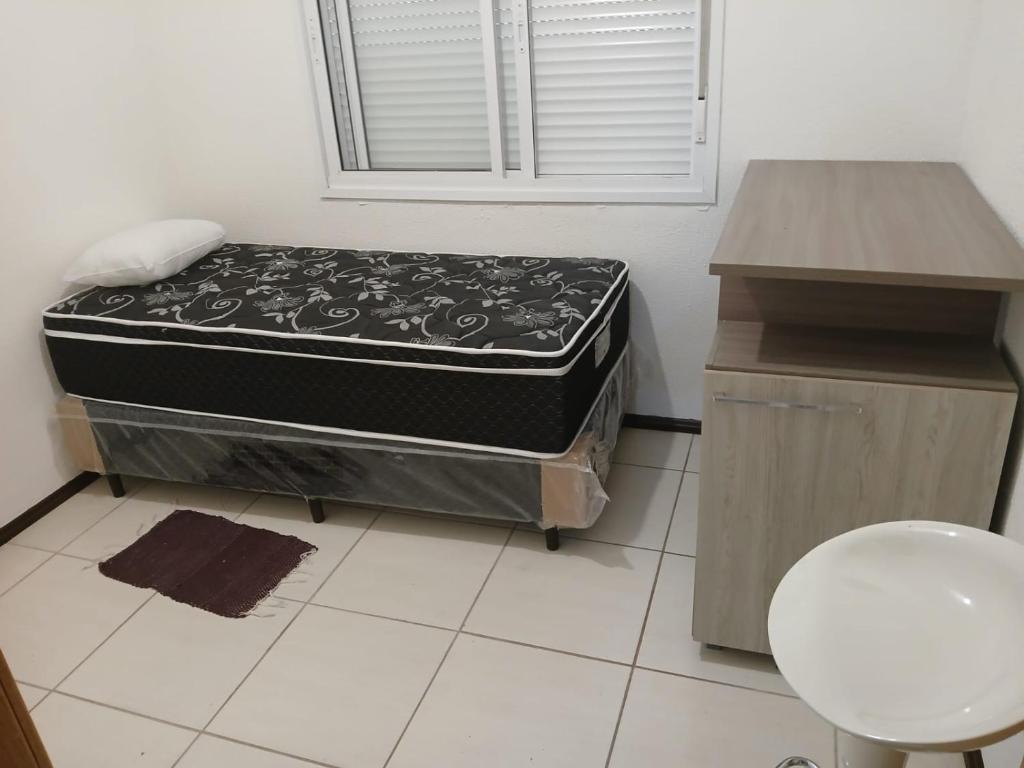 una habitación con una cama y un escritorio con un colchón en Apto linda vista, en Osório