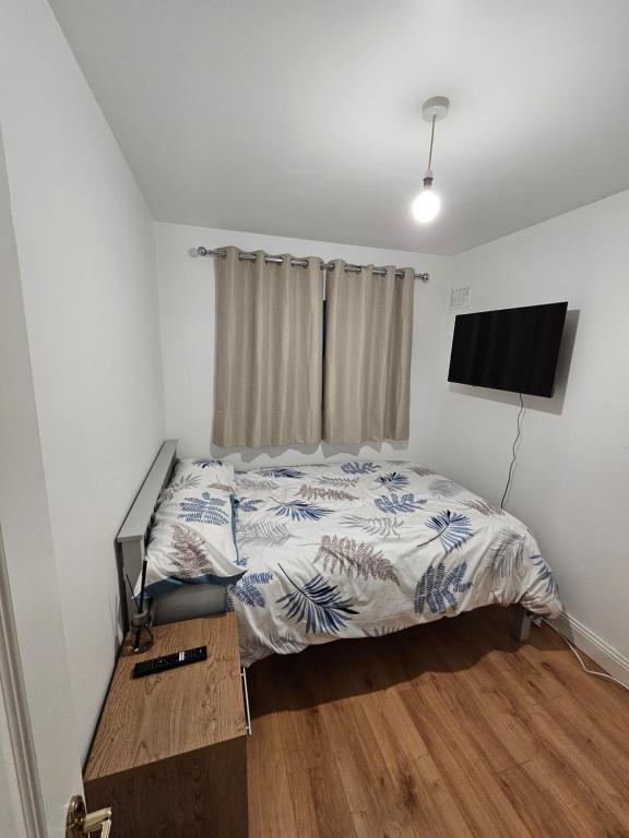 Un dormitorio con una cama y un televisor de pantalla plana. en Victor's guesthouse, en Waterford