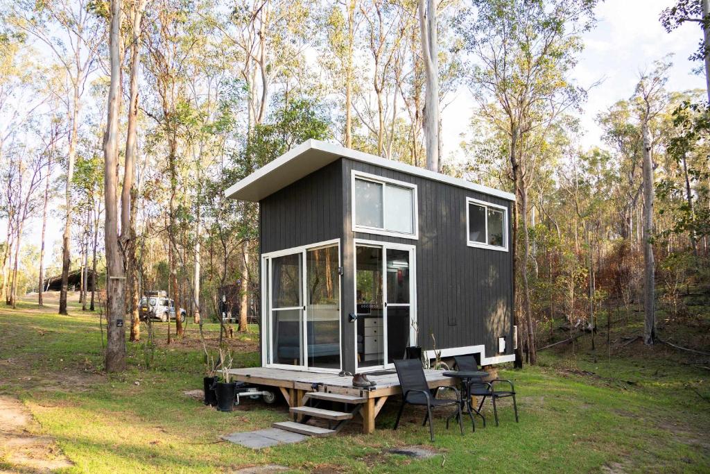 een zwart klein huisje met een picknicktafel in een veld bij Hidden Camp's Loft House by Tiny Away in Kanighan