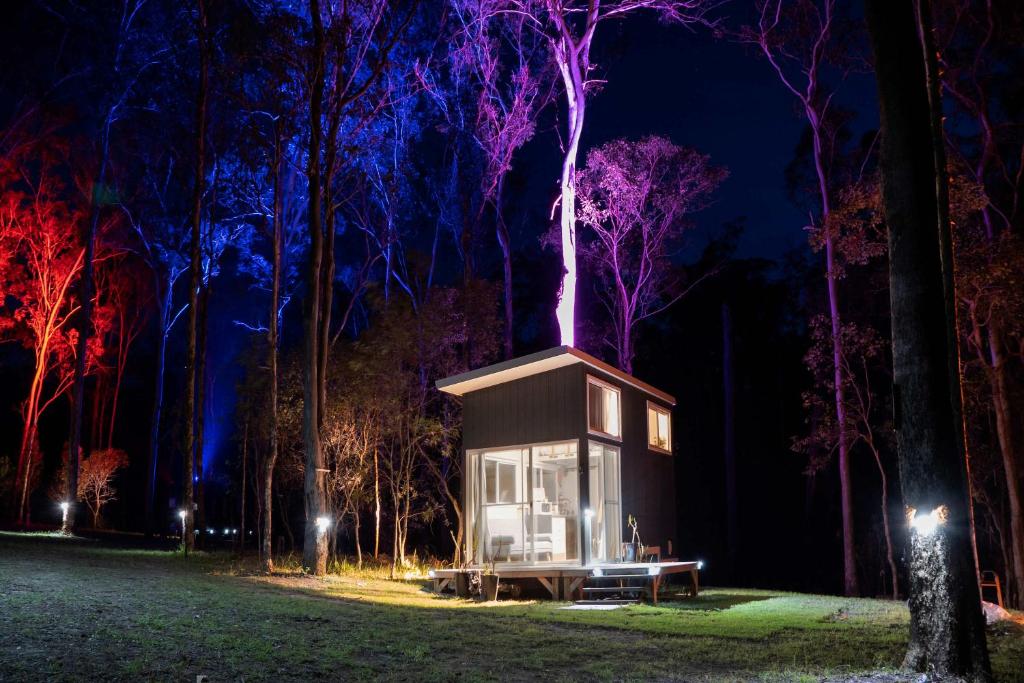a treehouse in the middle of a forest at night at Hidden Camp's Loft House by Tiny Away in Kanighan