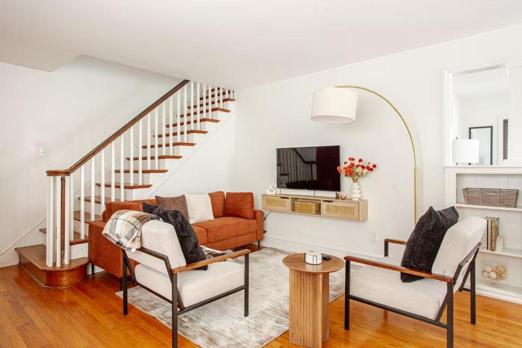 a living room with a couch and a tv at Elegant Spacious Retreat Perfect For Families in Wilmington