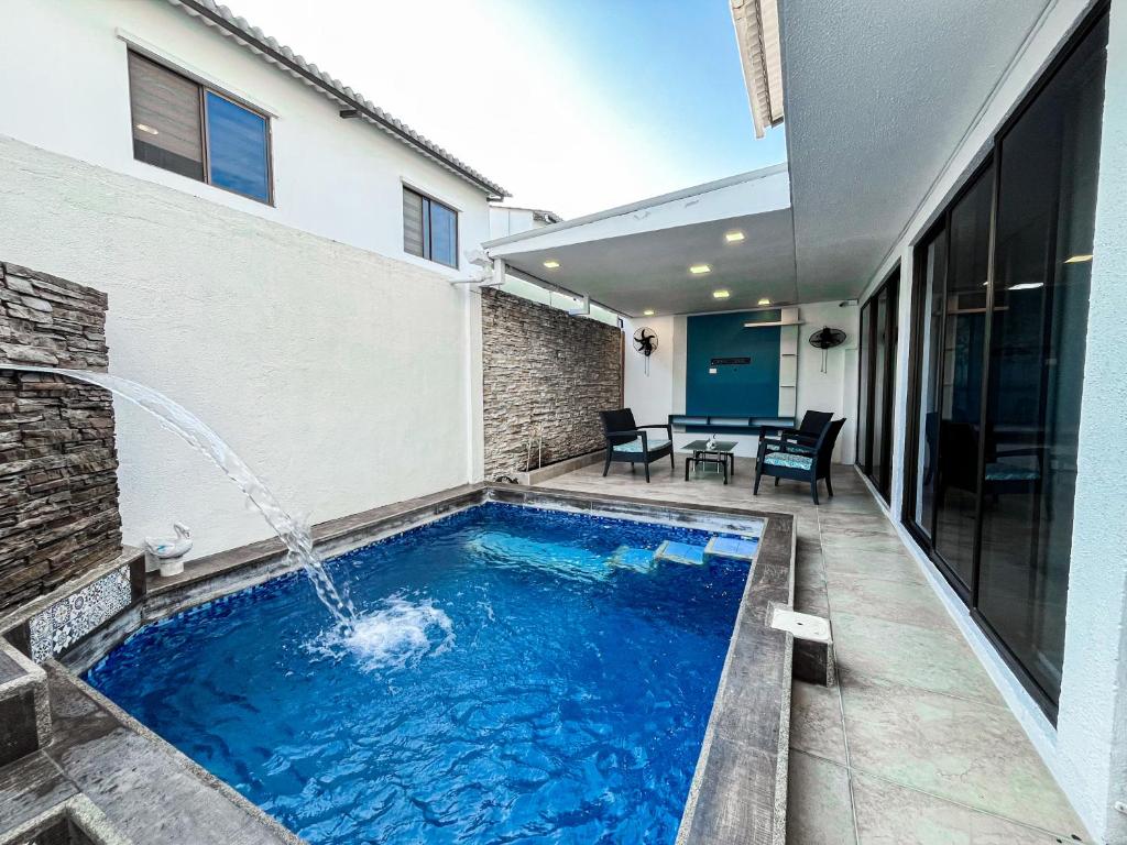 una piscina con fontana in una casa di Piscina con Bbq en Villa privada cerca de centros comerciales con 3 habitaciones, 5 Camas, seguridad 24-7 a Bellavista