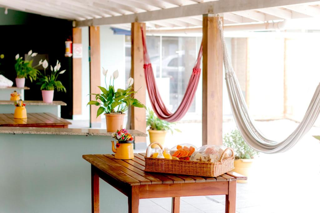 a table with a basket of fruit on it at Mares e Flores de Bombinhas in Bombinhas