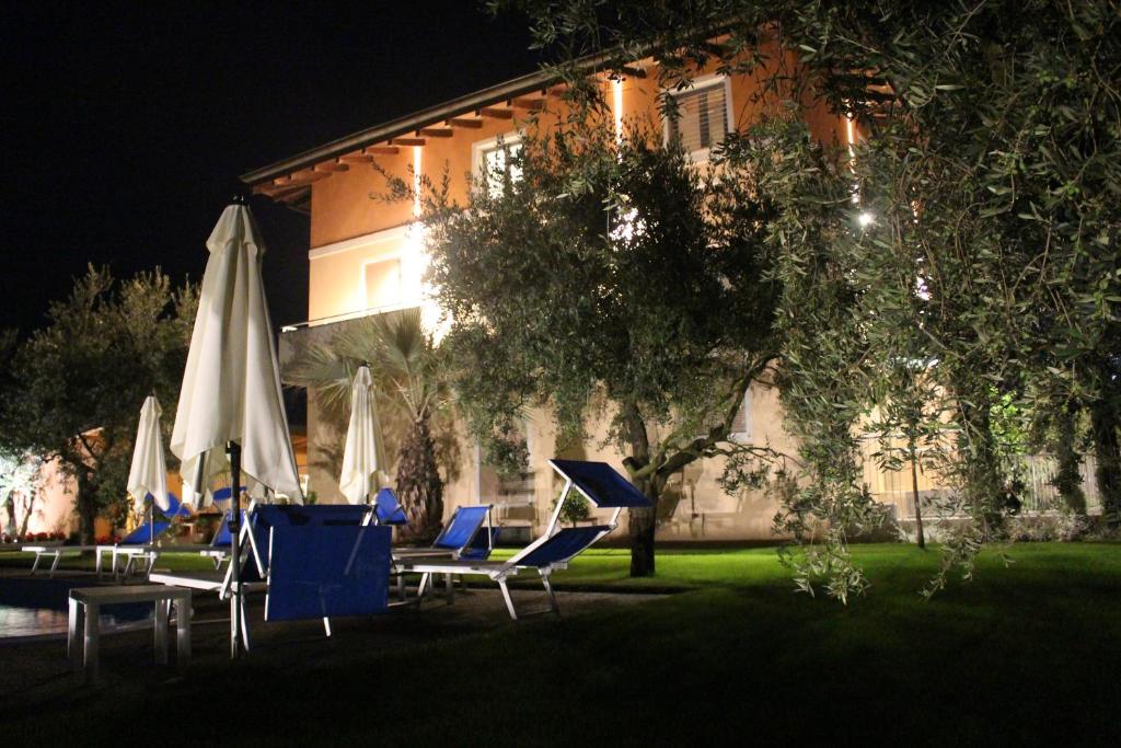 a group of chairs and umbrellas in front of a building at Agritur il Melograno in Arco