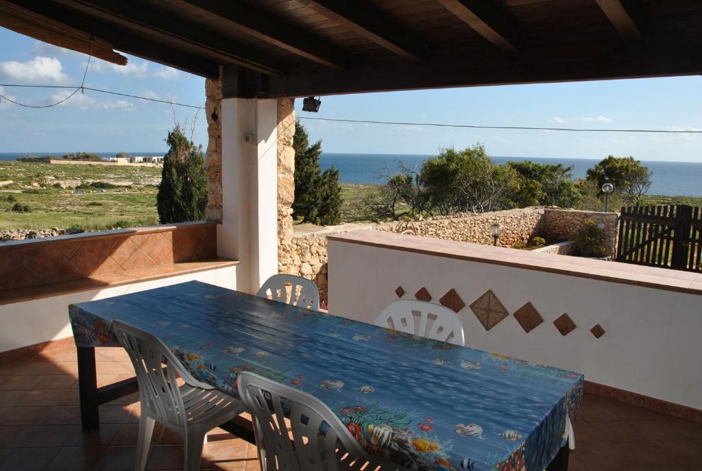 a blue table and chairs on a balcony with the ocean at Villetta Girasole in Lampedusa