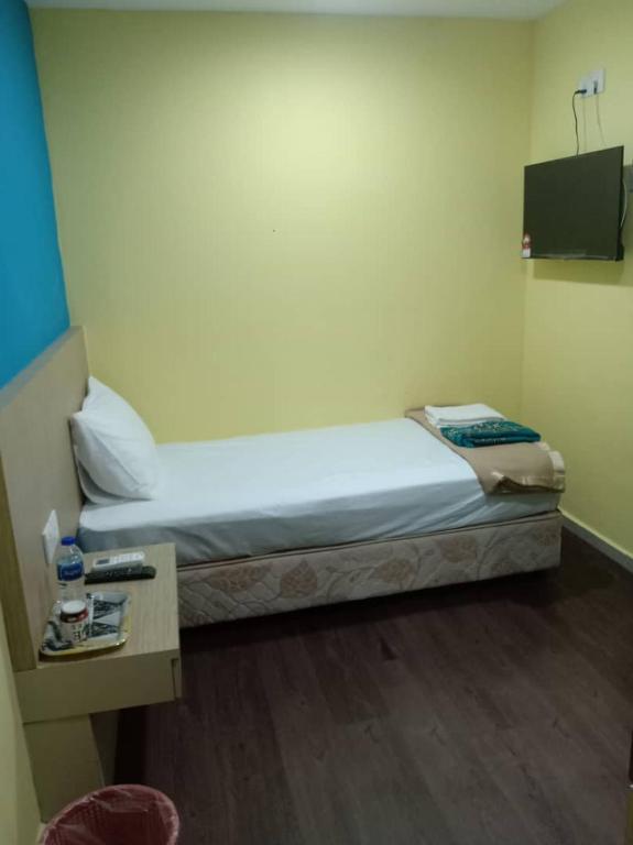 a small room with a bed and a table at Casa D'rose Hotel in Malacca