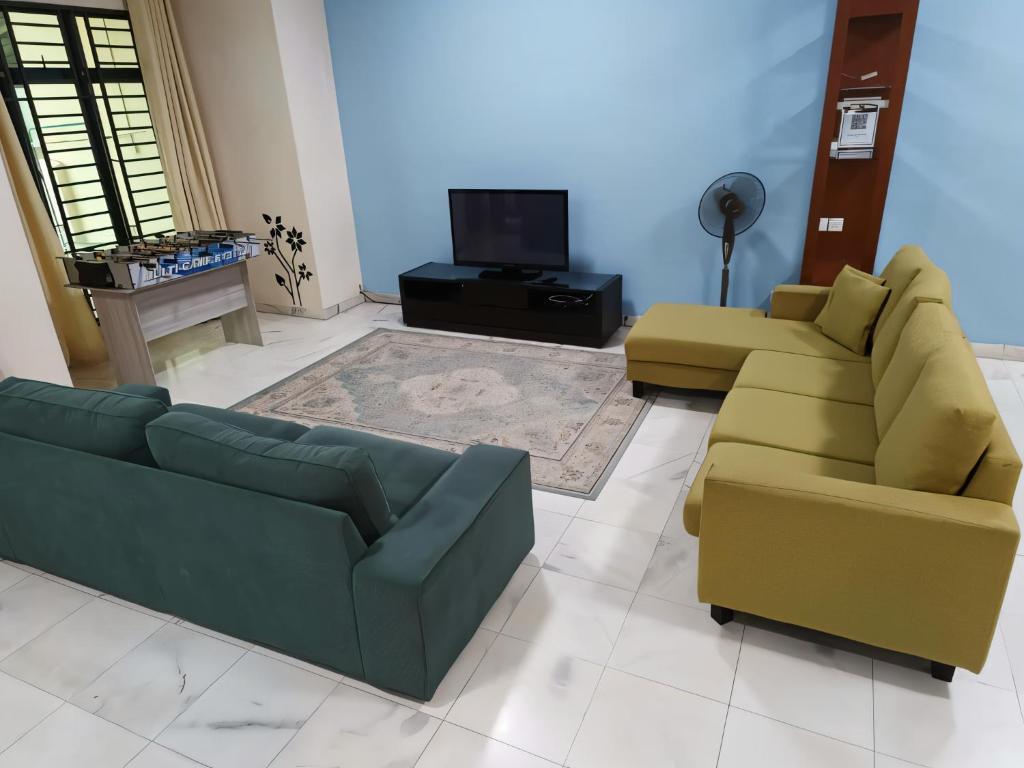 a living room with two couches and a television at Warisan Indah Homestay KLIA 2 Melayu sahaja in Sepang