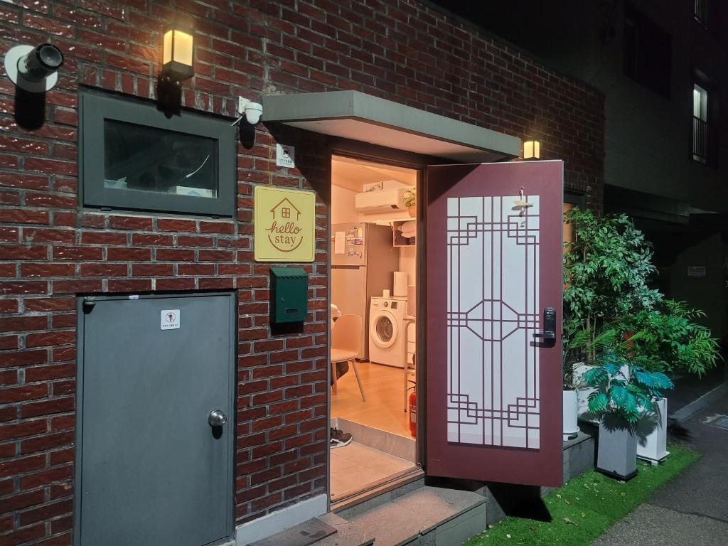 einen Eingang zu einem Backsteingebäude mit einer roten Tür in der Unterkunft Seoul & Hangang Park, 5 min walk from Konkuk University, Seongsu, Jayang Subway Stations & Licensed Accommodation in Seoul