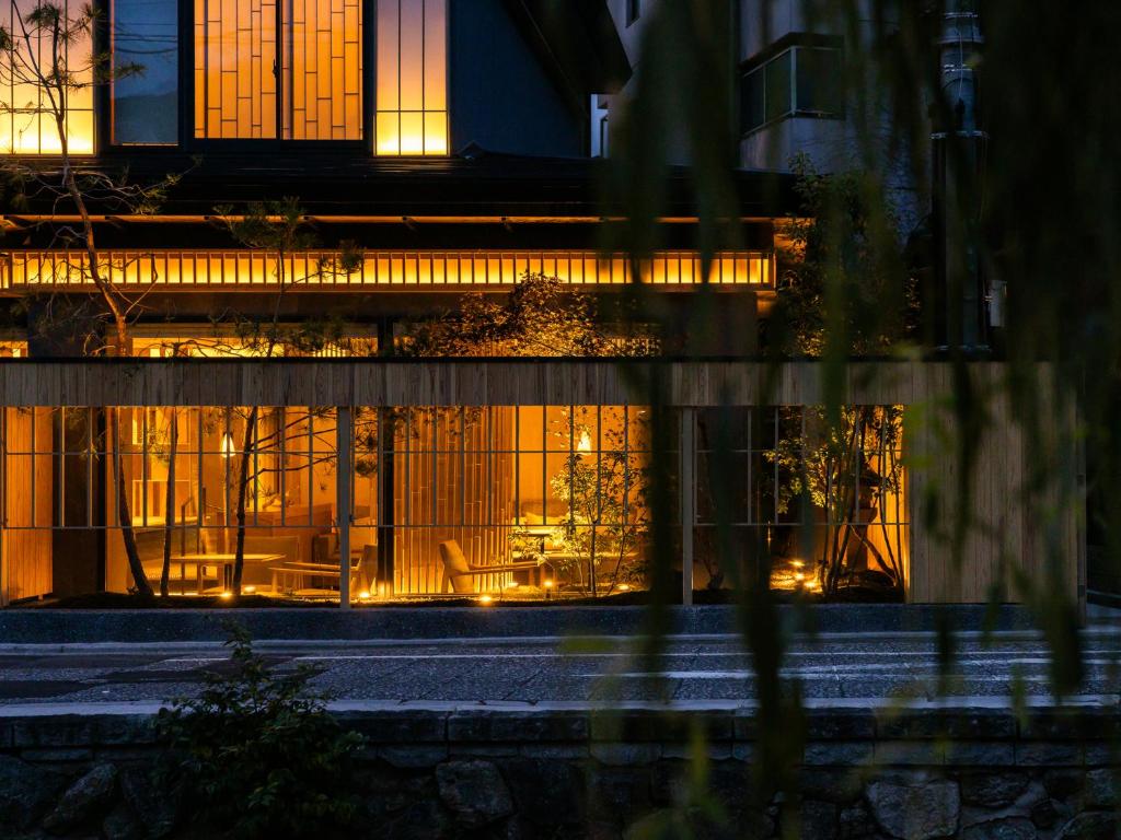 a building with lit up windows at night at AKEKURE Kyoto Shirakawa in Kyoto