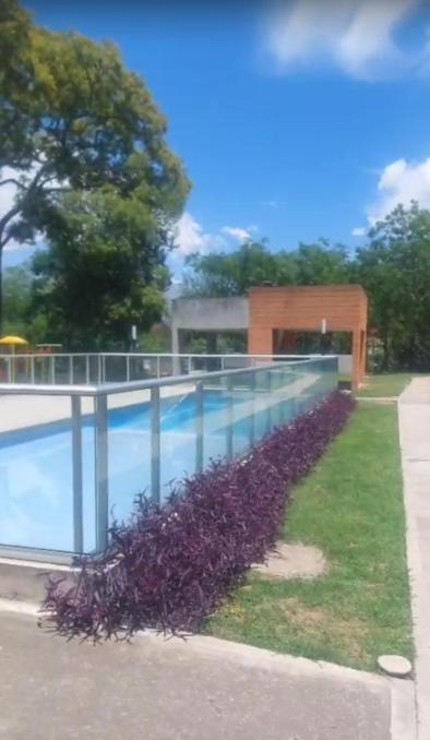 a swimming pool with purple plants next to a building at Villa Lastenia 2 in San Salvador de Jujuy