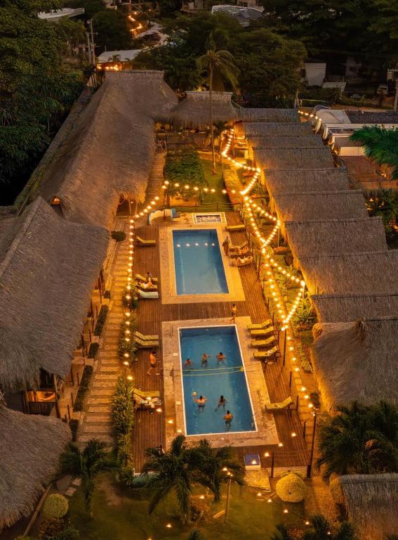 an overhead view of a swimming pool with lights at Tiki Hut Hostel in Palomino