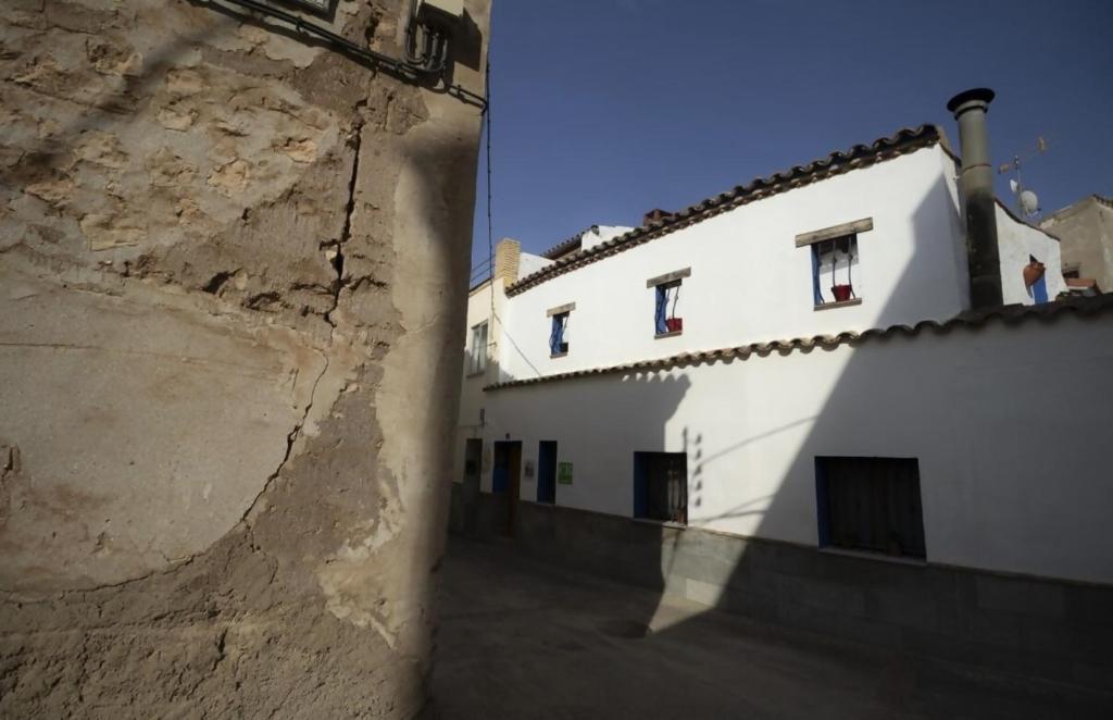 ein großes weißes Gebäude neben einer Mauer in der Unterkunft Casa rural Casa Leles in Lagata