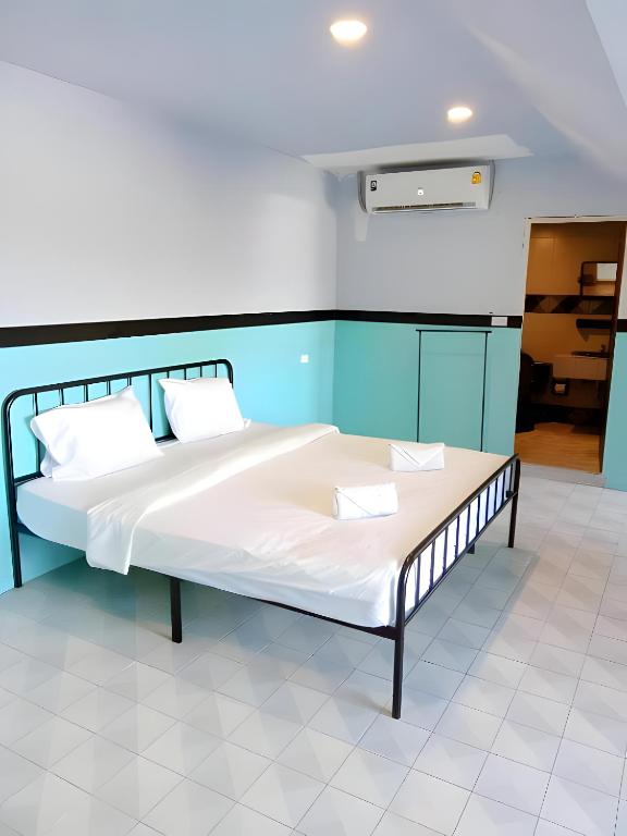 a bed with white sheets and pillows in a room at oo Mitr Inn Phuket Island - Phuket Old Town yes in Phuket