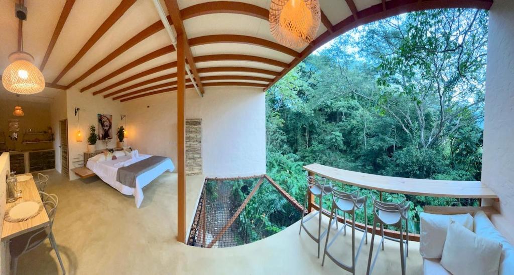 una camera con un letto e una grande finestra di Cabaña El Mamoncillo con Jacuzzi Privado y Malla Catamarán a Sopetrán