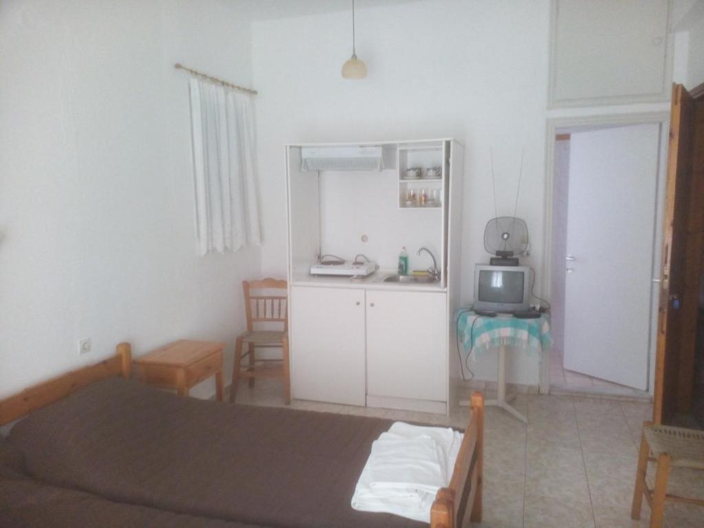 sypialnia z łóżkiem oraz kuchnia z kuchenką mikrofalową w obiekcie Karagiozos Studios & Apartments w mieście Skopelos