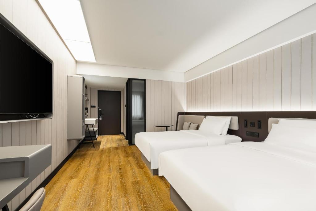 Ένα ή περισσότερα κρεβάτια σε δωμάτιο στο Hanting Hotel Shenzhen Guanlan Foxconn